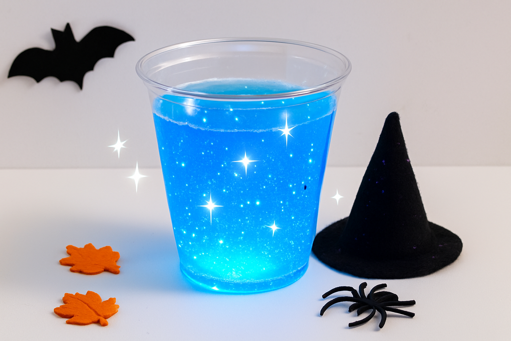 A square product photo of a glowing blue liquid in a clear cup under blacklight effect, with sparkles and a wizard hat nearby. Styled with subtle Halloween accents. Bright, modern fall STEM kit look on a white background.”